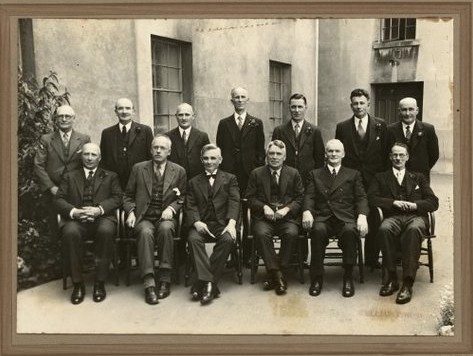 The Labour government of New Zealand that would commission the Thomas Report. In 1935 Rex Mason was not yet Minister of Education [back row, 4th from left]. The future Prime Minister, Fraser is 2nd from left, front row. Photograph taken by A W Schaef. Gustafson, Barry. Ref: PAColl-3222-3-002. Alexander Turnbull Library, Wellington, New Zealand. http://natlib.govt.nz/records/22641171